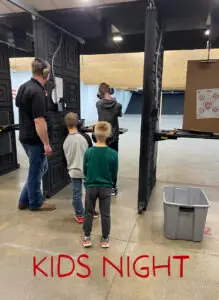 Kids being taught to shoot at indoor shooting range